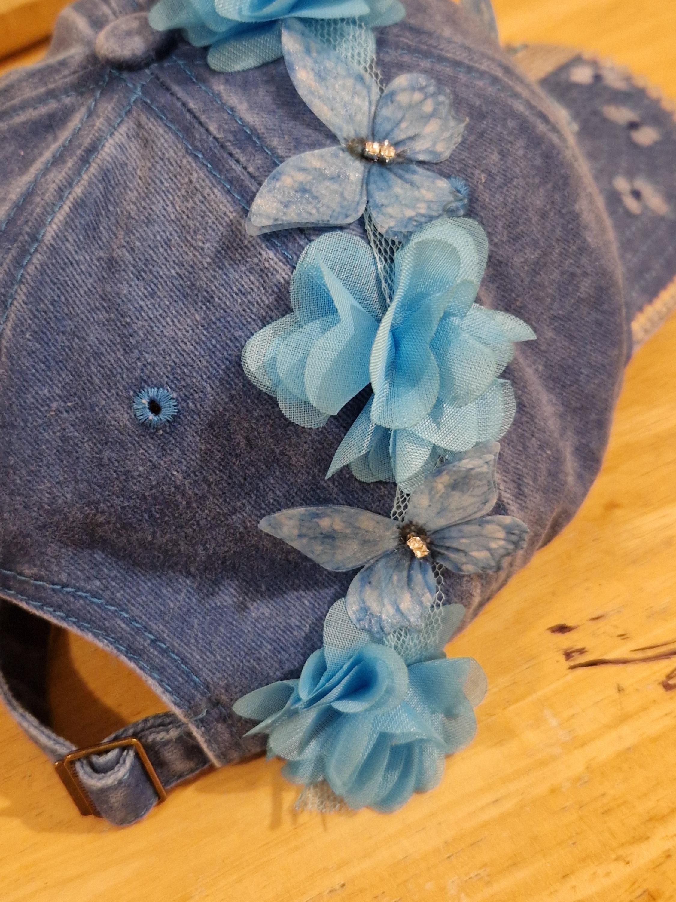 Blue distressed denim baseball cap with nature inspired embellishments