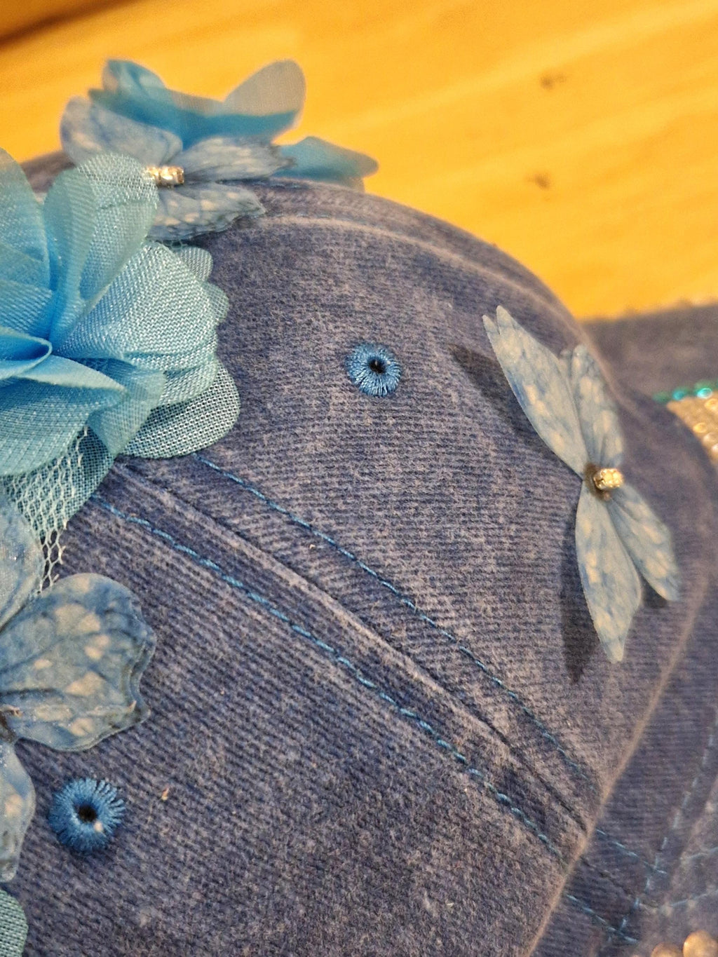 Blue distressed denim baseball cap with nature inspired embellishments